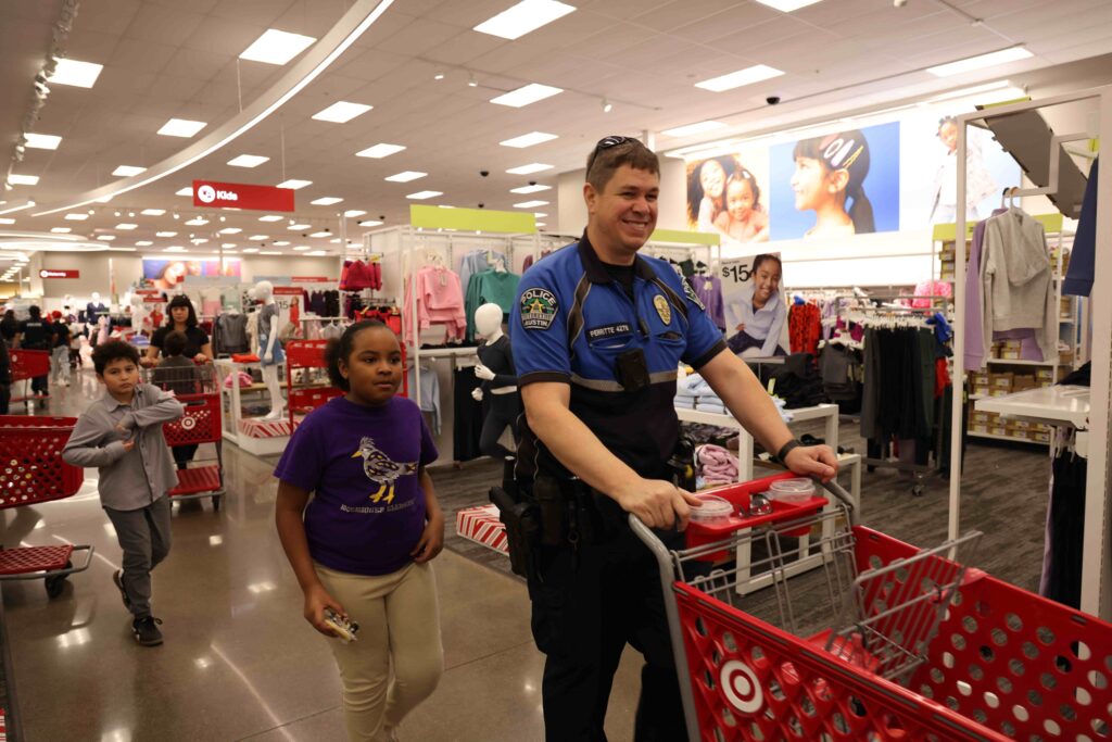 An officer shopping with children in a clothing store.