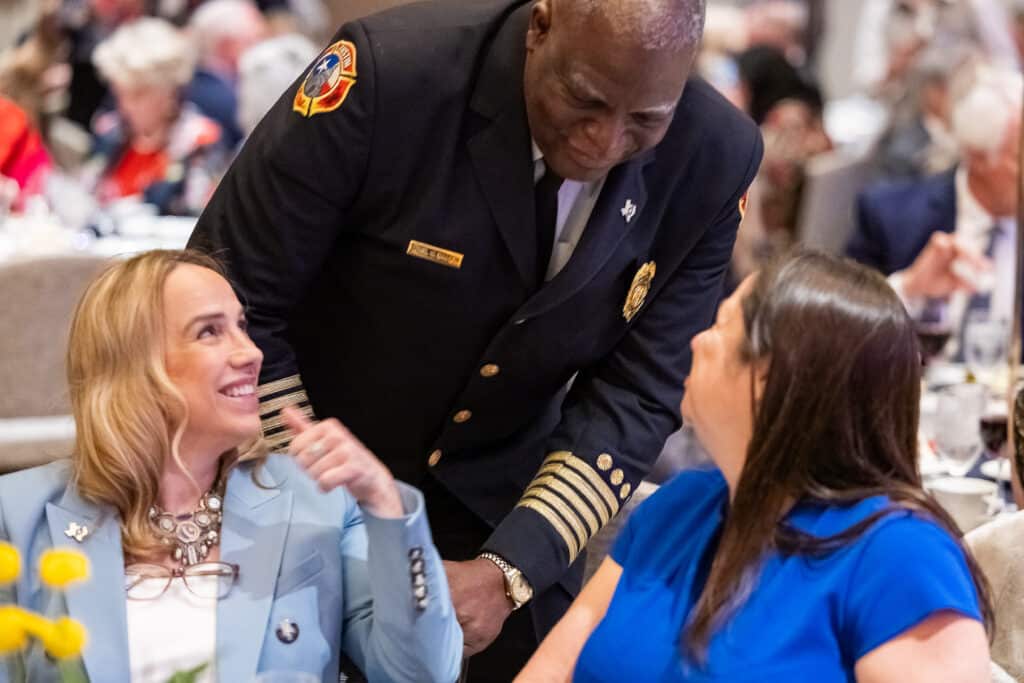 Two women meeting fire chief at event