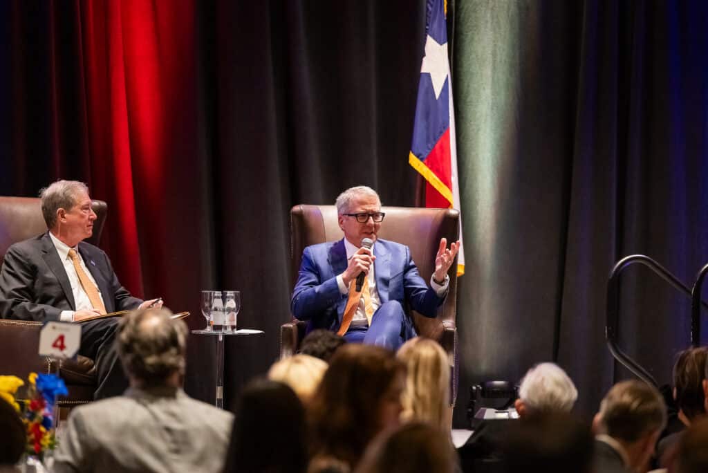 Two men speaking at a conference with audience