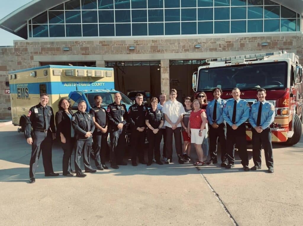 Group of EMTs and firefighters outside station