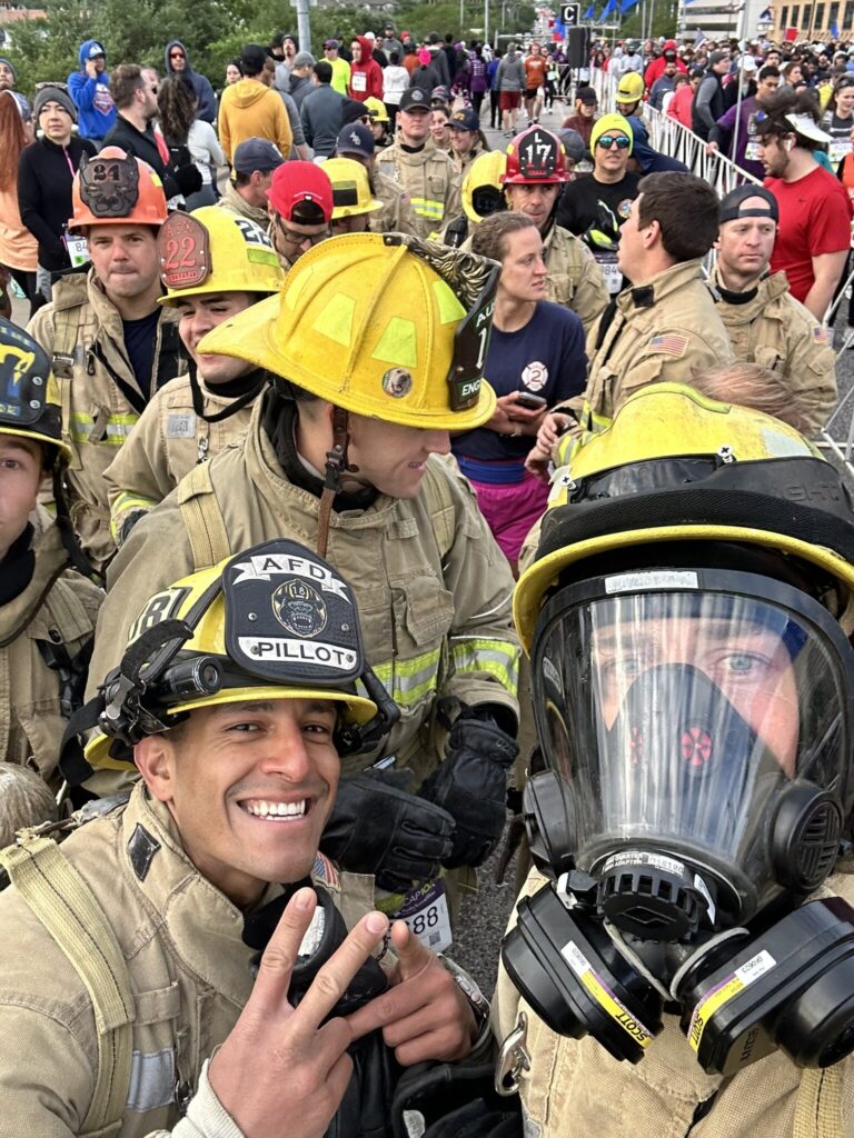 Firefighters in gear at a crowded outdoor event.