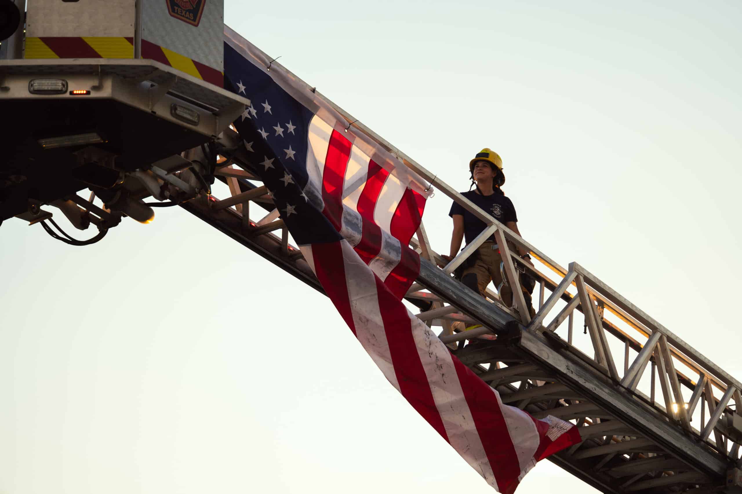 Firefighter on ladder with American flag